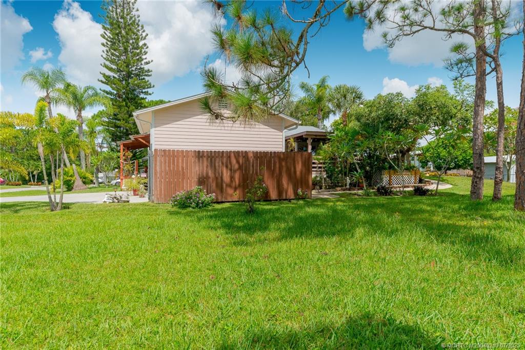 4171 Southeast Robert Loop Road Stuart, FL 34997 - Photo 24 of 27 a view of a house with backyard and a tree