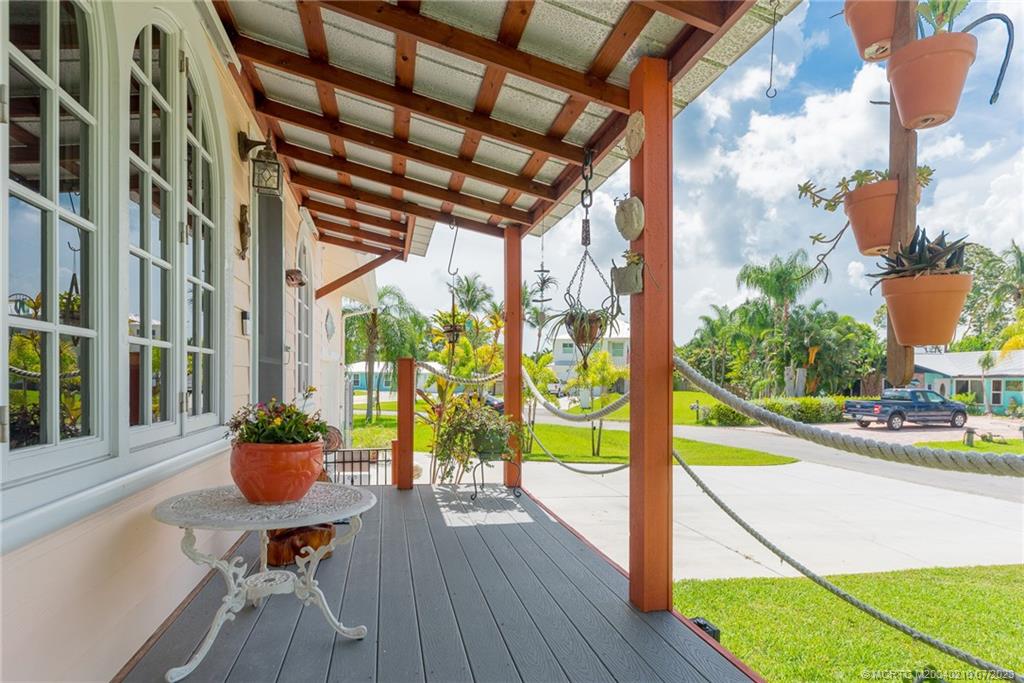 4171 Southeast Robert Loop Road Stuart, FL 34997 - Photo 3 of 27 a view of a porch with chairs and potted plants