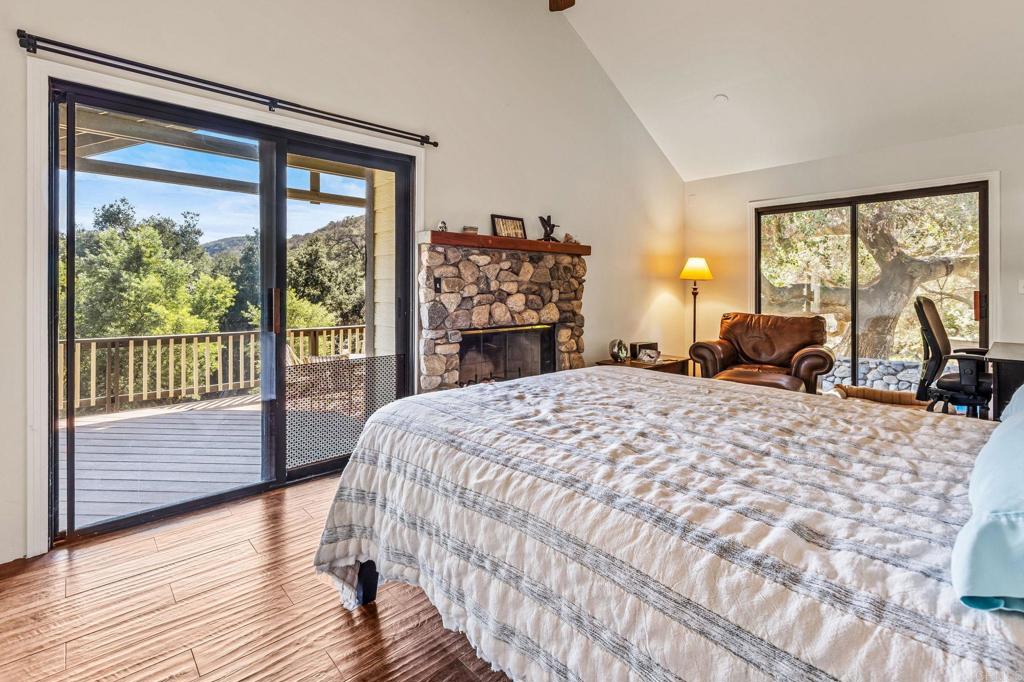 29533 Anthony Road Valley Center, CA 92082 - Photo 30 of 71 Wood burning fireplace and outside doors to covered patio overlooking natural setting.