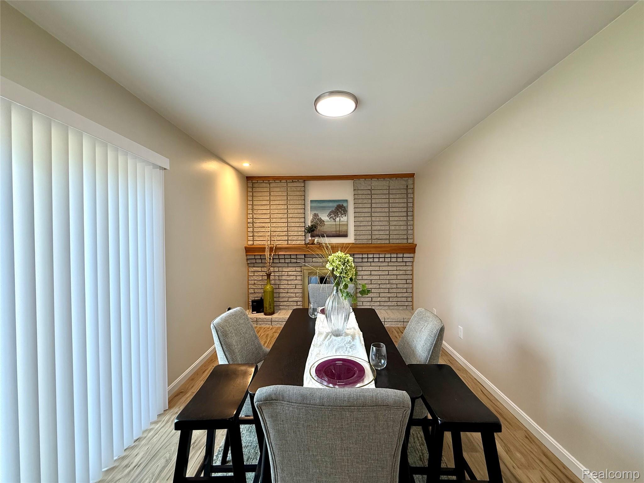 39909 Lynn Street Canton, MI 48187 - Photo 13 of 45 Dining area featuring wood-finish flooring, a brick fireplace with a wood mantle, and a flush-mount ceiling light