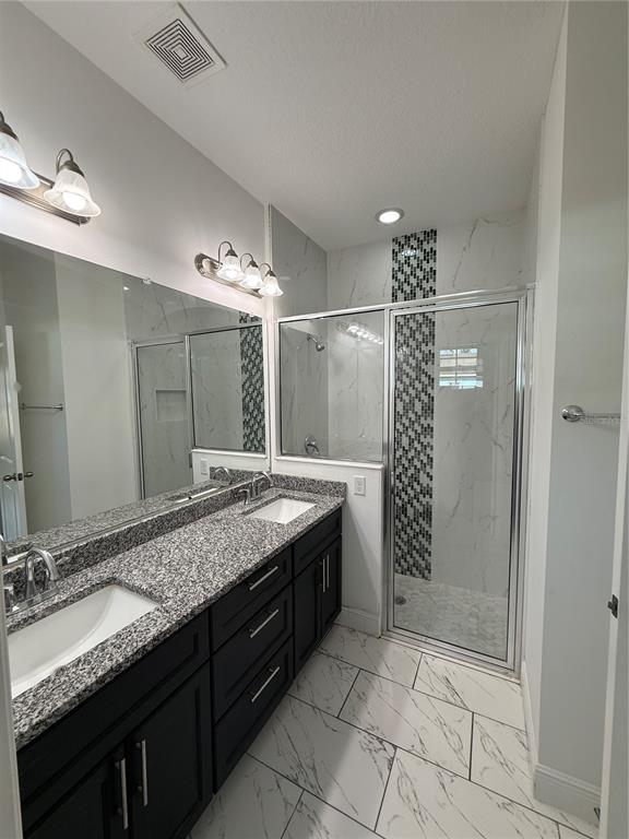 2314 Apache Avenue Kissimmee, FL 34744 - Photo 19 of 29 a bathroom with a granite countertop sink a large mirror and a shower