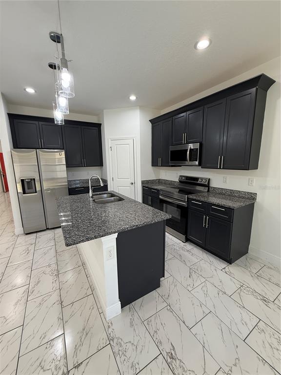 2314 Apache Avenue Kissimmee, FL 34744 - Photo 8 of 29 a kitchen with stainless steel appliances granite countertop a stove a sink a microwave and a refrigerator