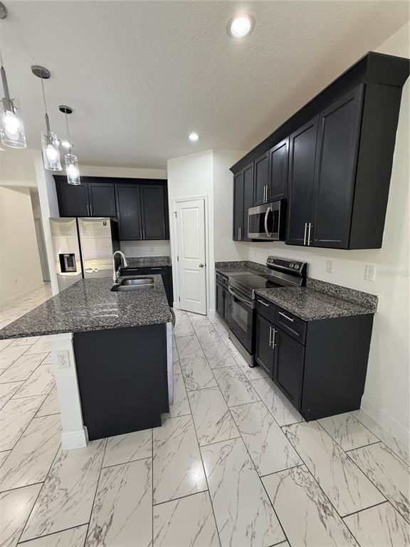 2314 Apache Avenue Kissimmee, FL 34744 - Photo 10 of 29 a kitchen with stainless steel appliances granite countertop a stove a sink and a microwave