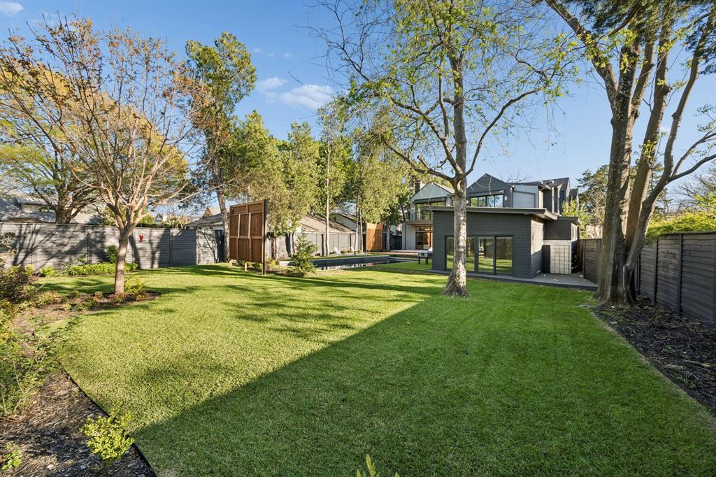 4323 Middleton Road Dallas, TX 75229 - Photo 38 of 40 Expansive backyard with a true balance of elements, lush lawn for play or pets alongside the pool and cabana. A rare combination that offers both clean architectural outdoor living and usable green space.