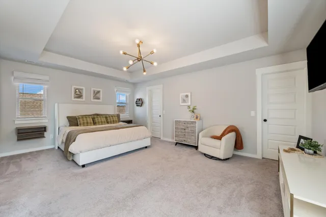 a spacious bedroom with a bed and a chandelier