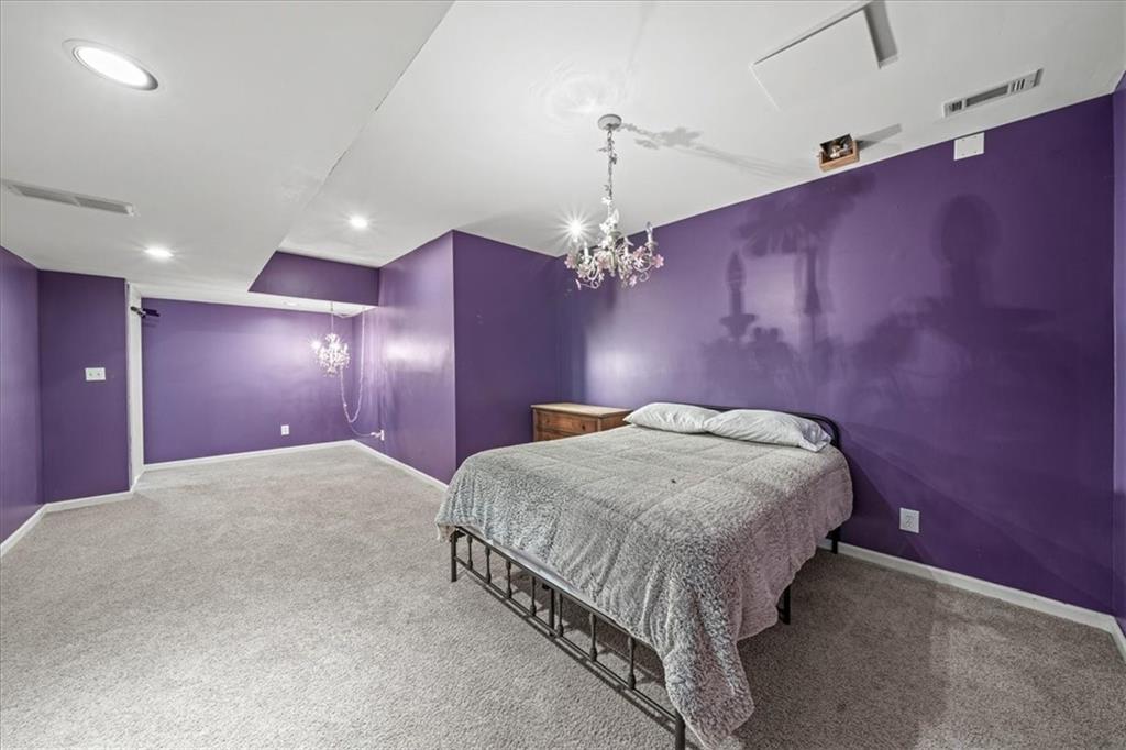 605 Pine Trail Pointe Roswell, GA 30075 - Photo 65 of 76 a spacious bedroom with a bed and a chandelier