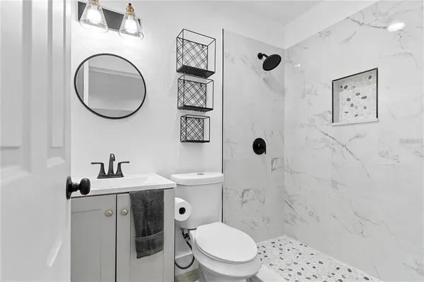 a bathroom with a sink a toilet and shower