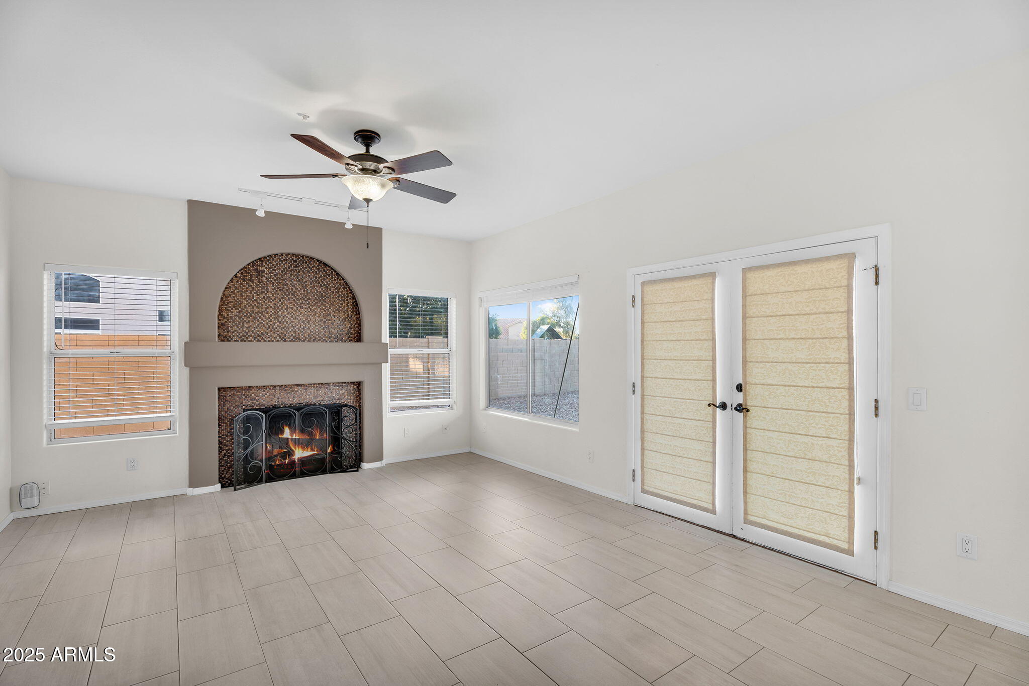 14566 North 100th Place Scottsdale, AZ 85260 - Photo 6 of 34 an empty room with fireplace chandelier fan and windows