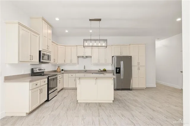 a kitchen with stainless steel appliances granite countertop a refrigerator a sink dishwasher a stove and white cabinets with wooden floor