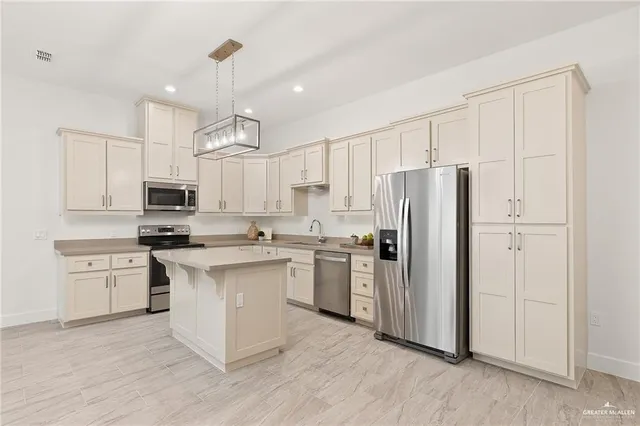 a kitchen with stainless steel appliances granite countertop a refrigerator oven a sink dishwasher and white cabinets with wooden floor