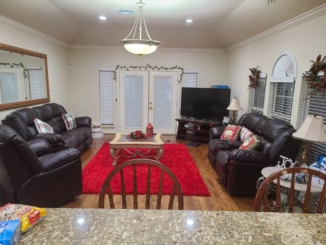 a living room with furniture a flat screen tv and a large window