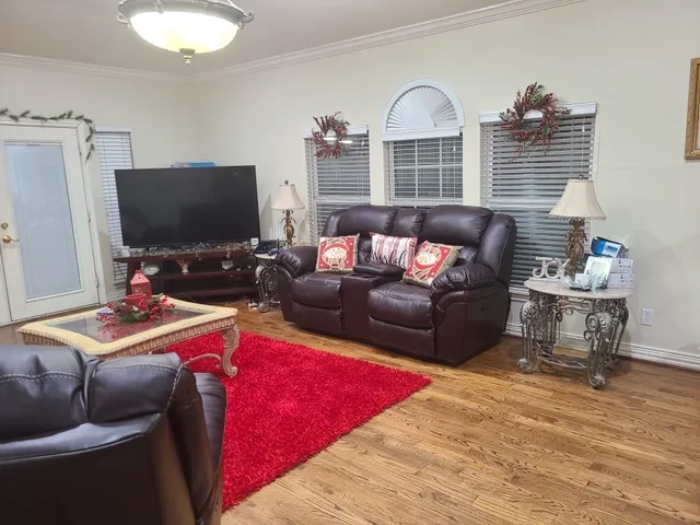 a living room with furniture a flat screen tv and a window