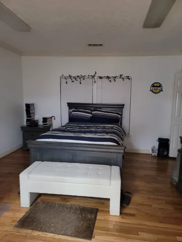 a bedroom with a bed and wooden floor