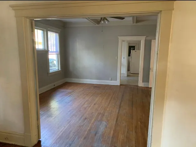 a view of a hallway with wooden floor and a window