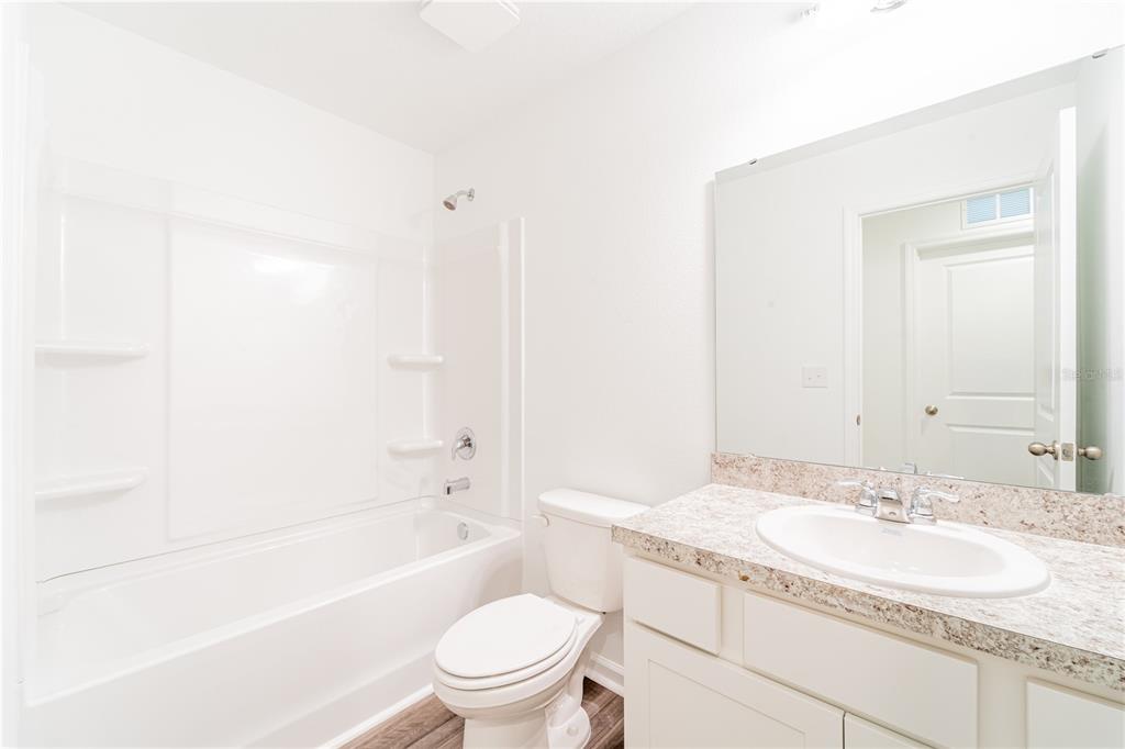 6174 Daerr Rdg Street Zephyrhills, FL 33542 - Photo 13 of 41 a bathroom with a granite countertop sink a toilet and shower