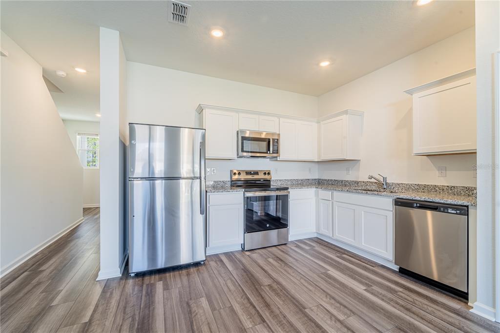 6174 Daerr Rdg Street Zephyrhills, FL 33542 - Photo 27 of 41 a kitchen with a refrigerator stove and wooden cabinets