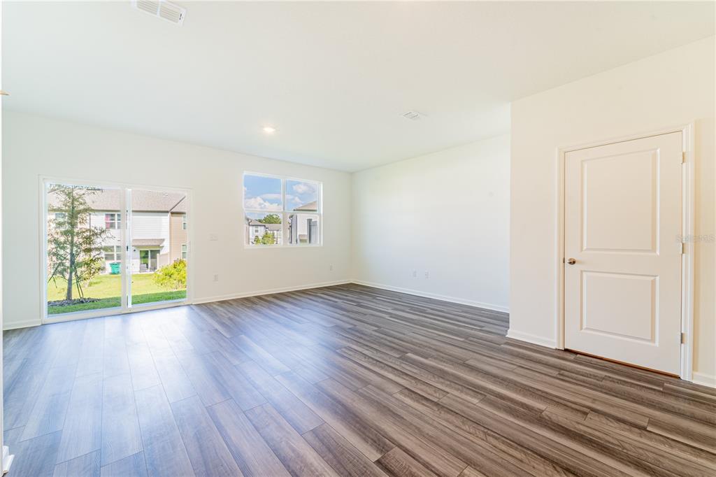 6174 Daerr Rdg Street Zephyrhills, FL 33542 - Photo 34 of 41 an empty room with wooden floor and windows