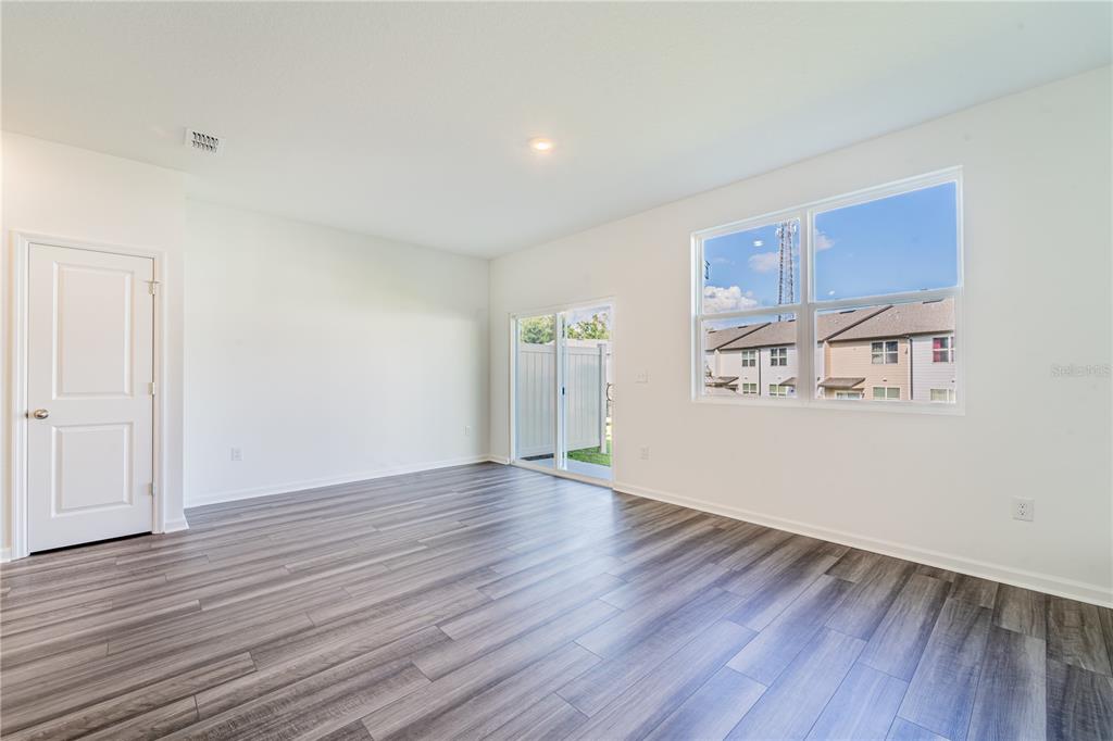 6174 Daerr Rdg Street Zephyrhills, FL 33542 - Photo 35 of 41 an empty room with wooden floor and windows