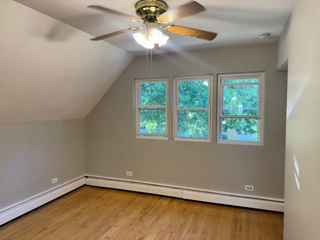 an empty room with a window and ceiling fan