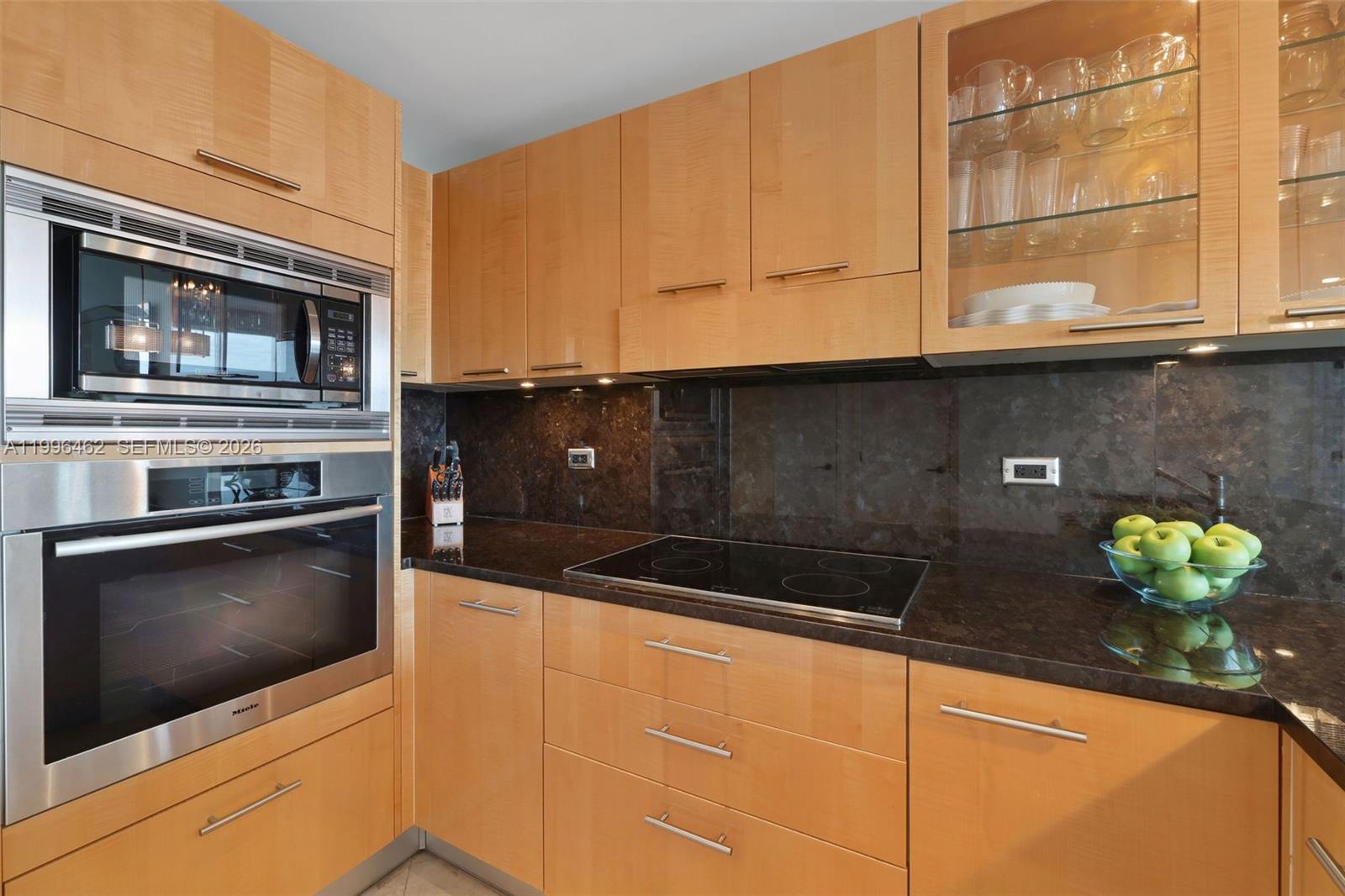 6799 Collins Avenue, Unit 1106 Miami Beach, FL 33141 - Photo 3 of 35 a kitchen with stainless steel appliances granite countertop a sink a stove and cabinets