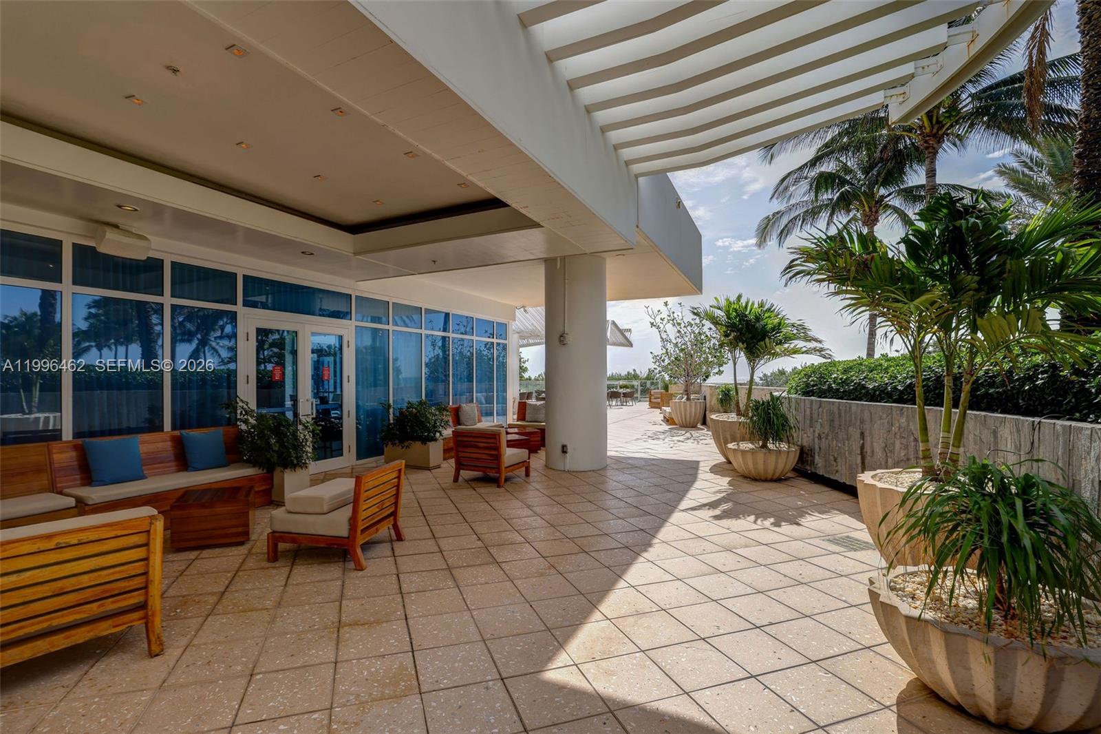 6799 Collins Avenue, Unit 1106 Miami Beach, FL 33141 - Photo 31 of 35 a building outdoor space with patio furniture and potted plants