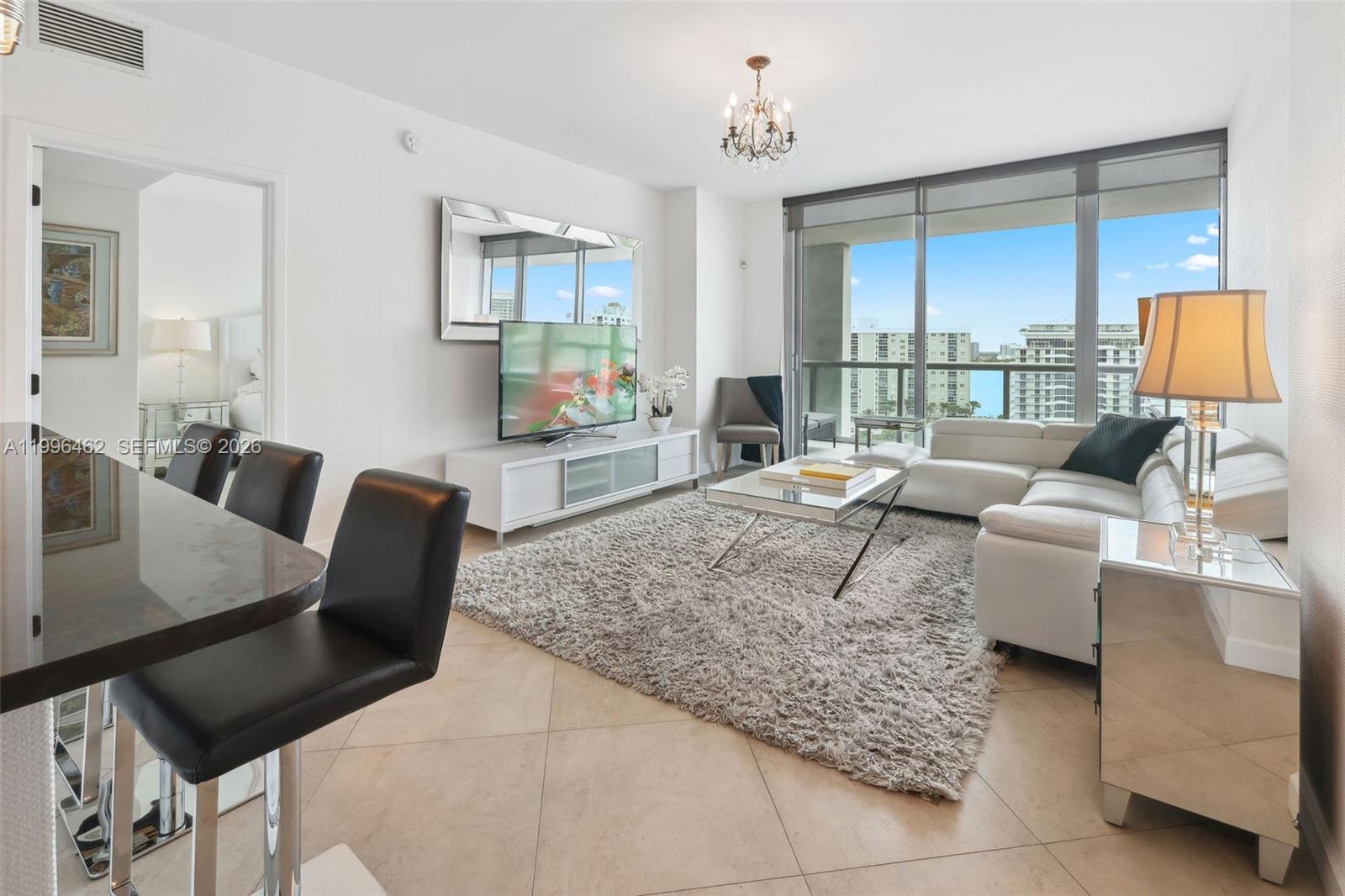 6799 Collins Avenue, Unit 1106 Miami Beach, FL 33141 - Photo 8 of 35 a living room with furniture and a lamp