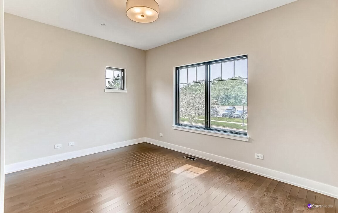 405 Duane Street Glen Ellyn, IL 60137 - Photo 7 of 12 an empty room with wooden floor and windows