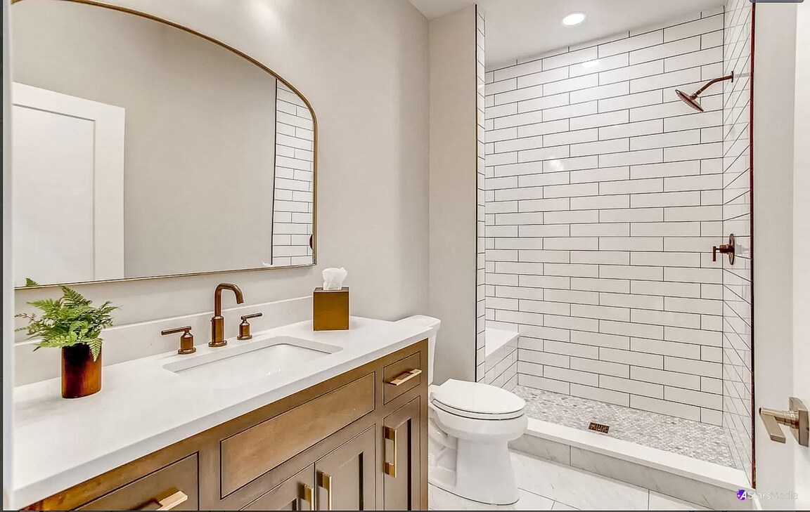 405 Duane Street Glen Ellyn, IL 60137 - Photo 9 of 12 a bathroom with a sink a toilet a mirror and shower