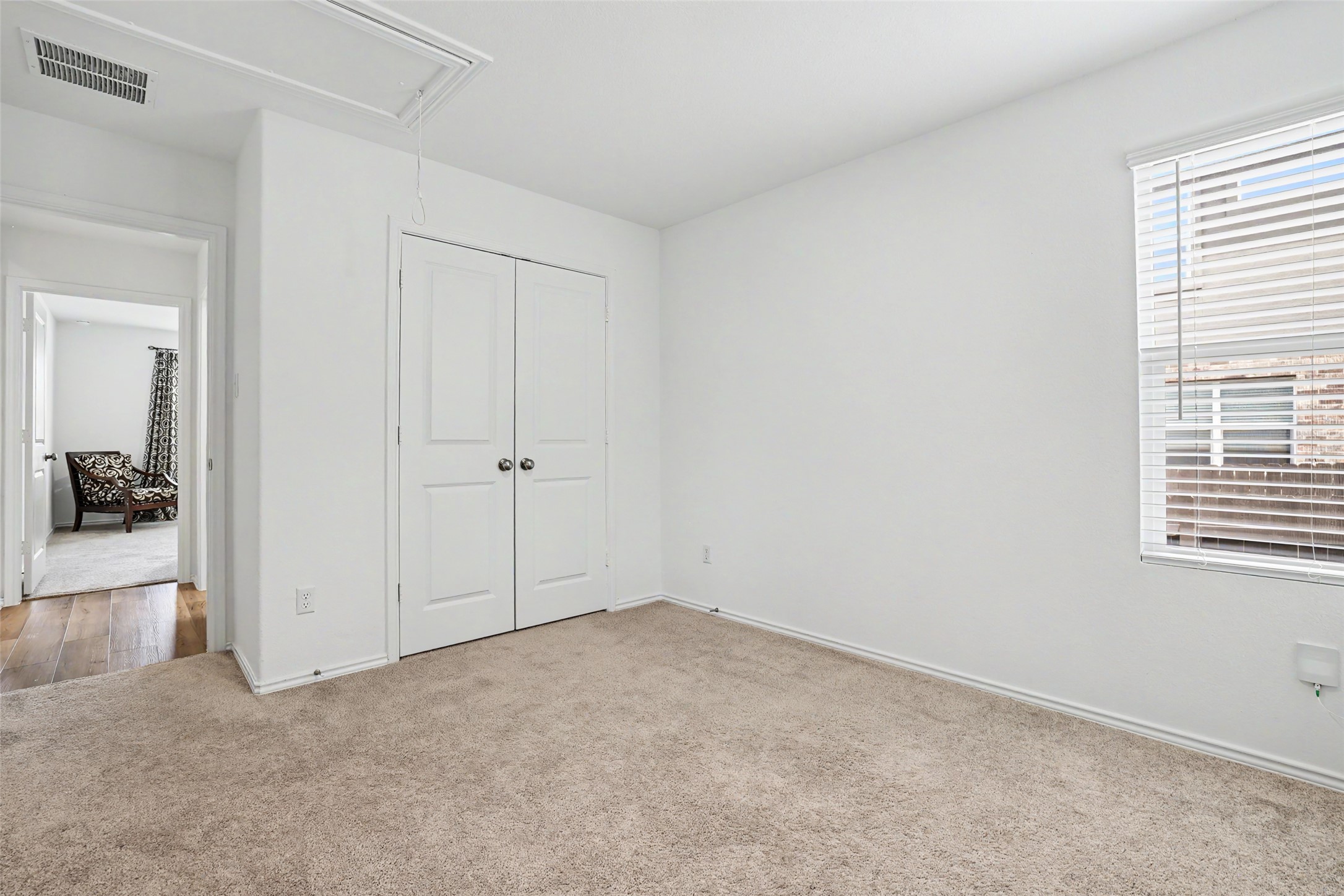 2333 Four Waters Loop Georgetown, TX 78628 - Photo 31 of 35 Carpeted room featuring a double-door closet with spherical hardware, white walls, and a window with blinds