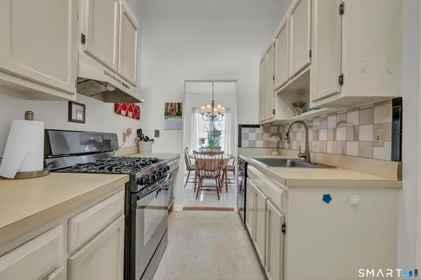 a kitchen with granite countertop a sink stove and cabinets