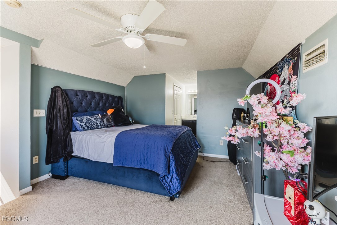 7393 Albany Road Fort Myers, FL 33967 - Photo 11 of 37 a bedroom with a bed and a chandelier