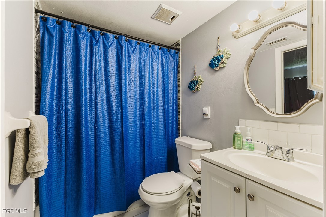7393 Albany Road Fort Myers, FL 33967 - Photo 16 of 37 a bathroom with a sink a toilet and shower curtain