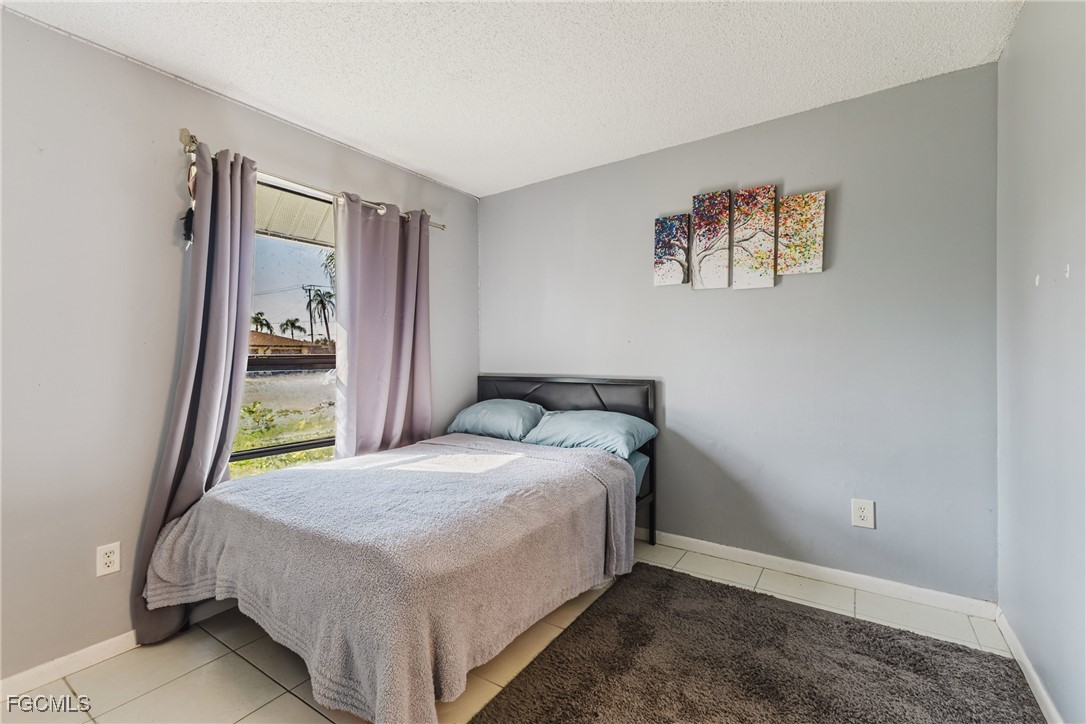 7393 Albany Road Fort Myers, FL 33967 - Photo 18 of 37 a bed sitting in a bedroom next to a window