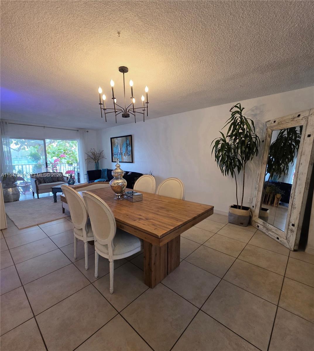 7424 Southwest 82nd Street, Unit D215 Miami, FL 33143 - Photo 13 of 33 a living room with furniture a chandelier and a fireplace