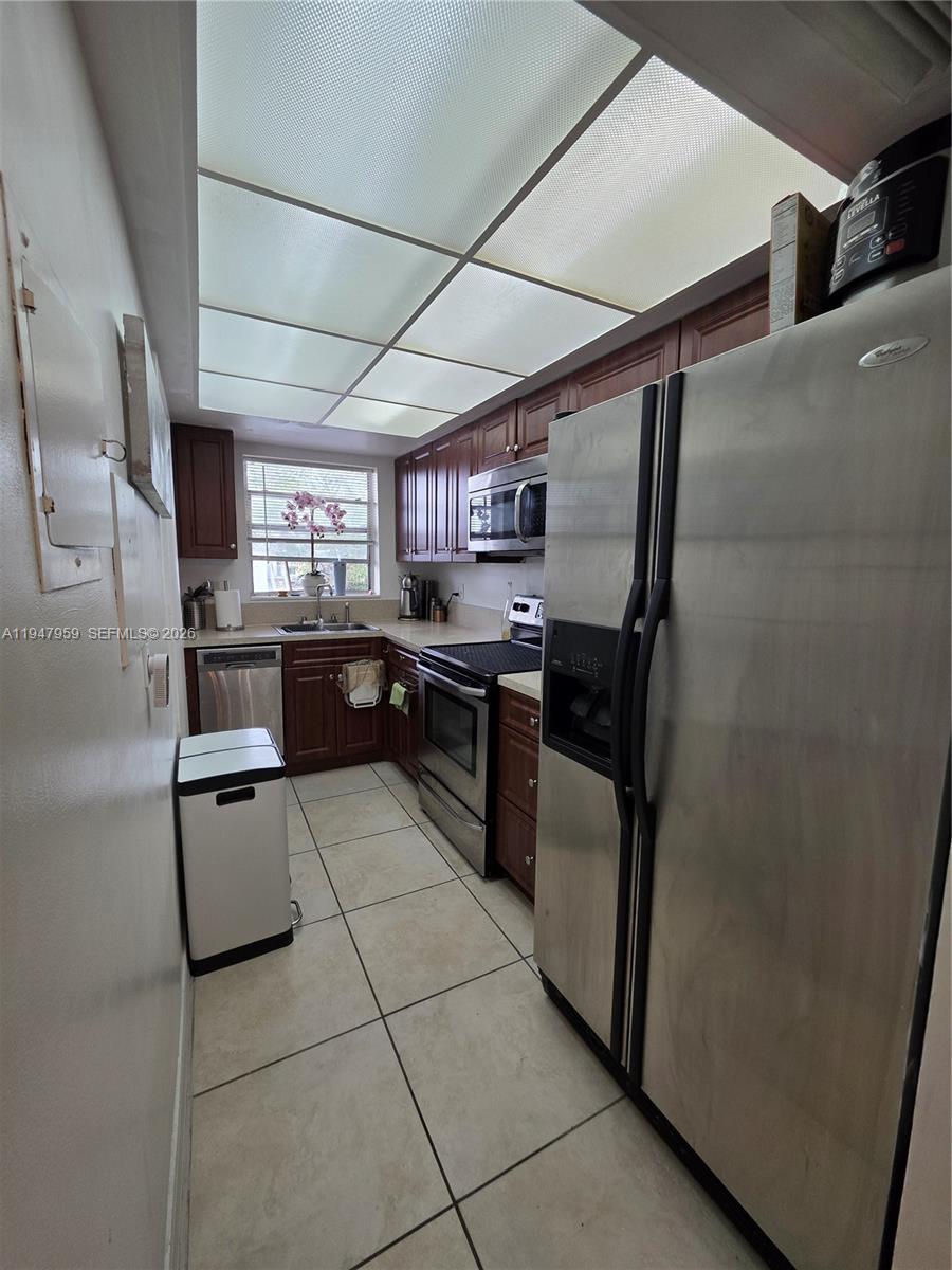 7424 Southwest 82nd Street, Unit D215 Miami, FL 33143 - Photo 16 of 33 a kitchen with stainless steel appliances granite countertop a refrigerator and a stove