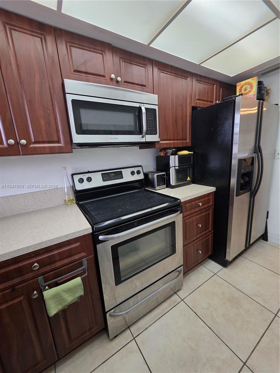7424 Southwest 82nd Street, Unit D215 Miami, FL 33143 - Photo 17 of 33 a kitchen with stainless steel appliances and stove top oven