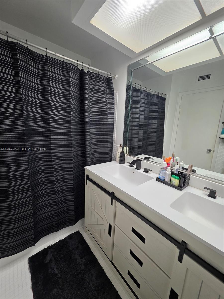 7424 Southwest 82nd Street, Unit D215 Miami, FL 33143 - Photo 23 of 33 a bathroom with a sink and a mirror