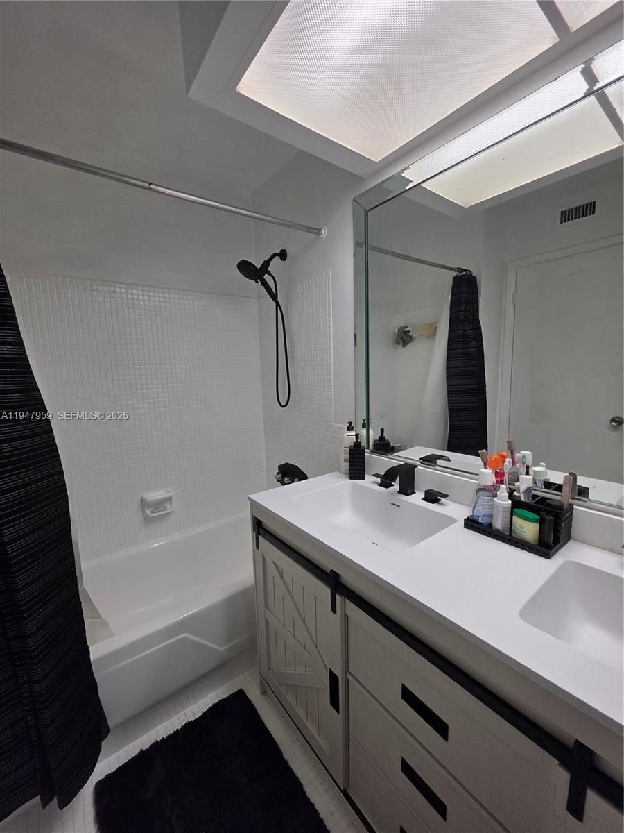 7424 Southwest 82nd Street, Unit D215 Miami, FL 33143 - Photo 24 of 33 a bathroom with a tub sink and mirror