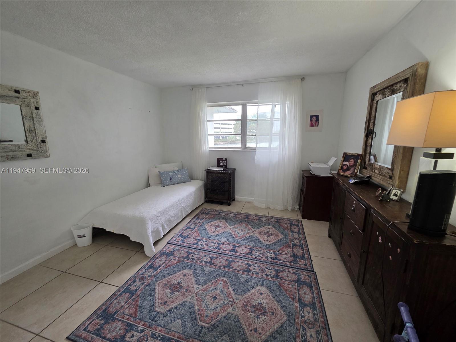 7424 Southwest 82nd Street, Unit D215 Miami, FL 33143 - Photo 26 of 33 a bedroom with a bed and wooden floor