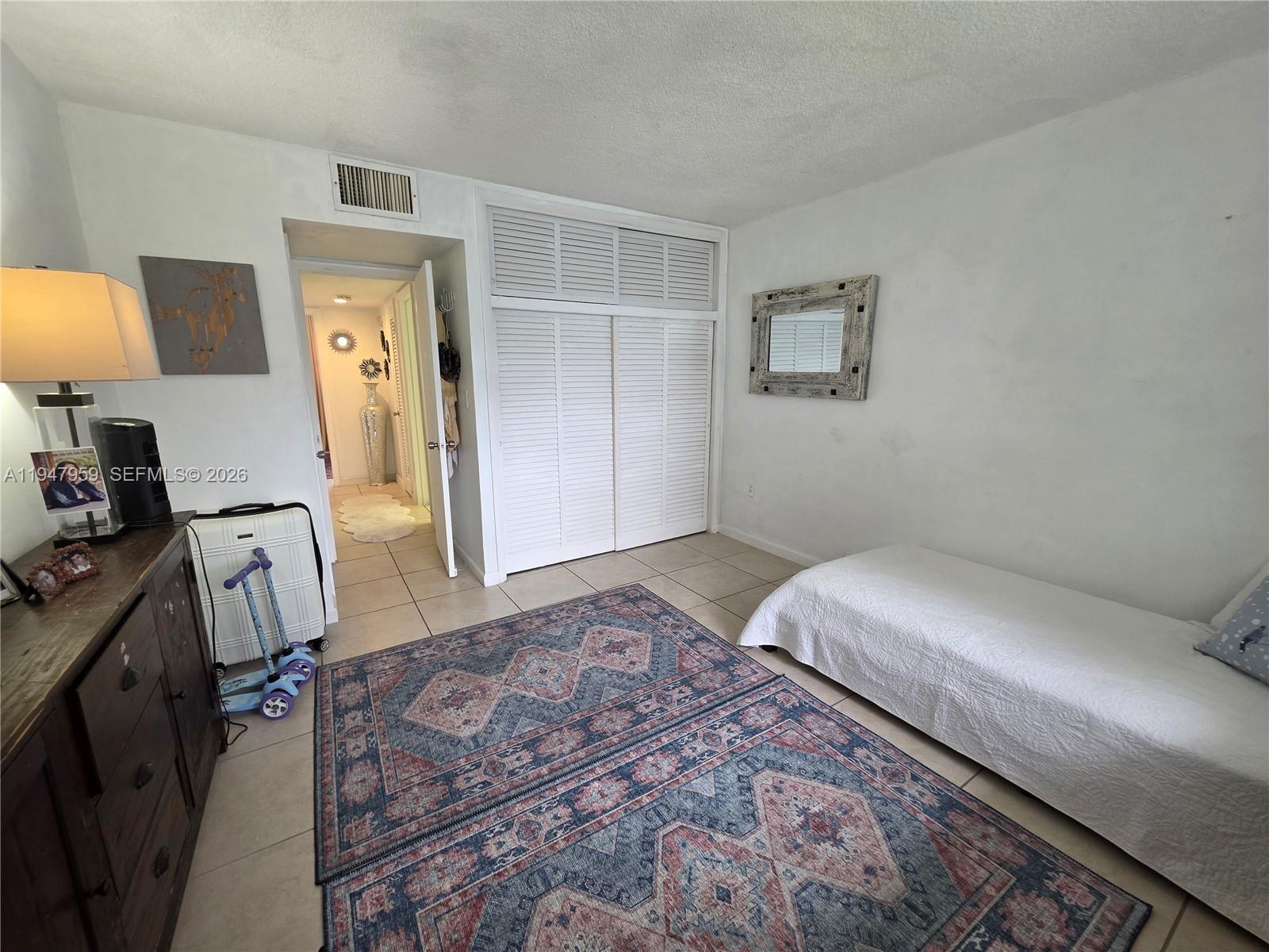 7424 Southwest 82nd Street, Unit D215 Miami, FL 33143 - Photo 27 of 33 a bedroom with a bed and a table in it