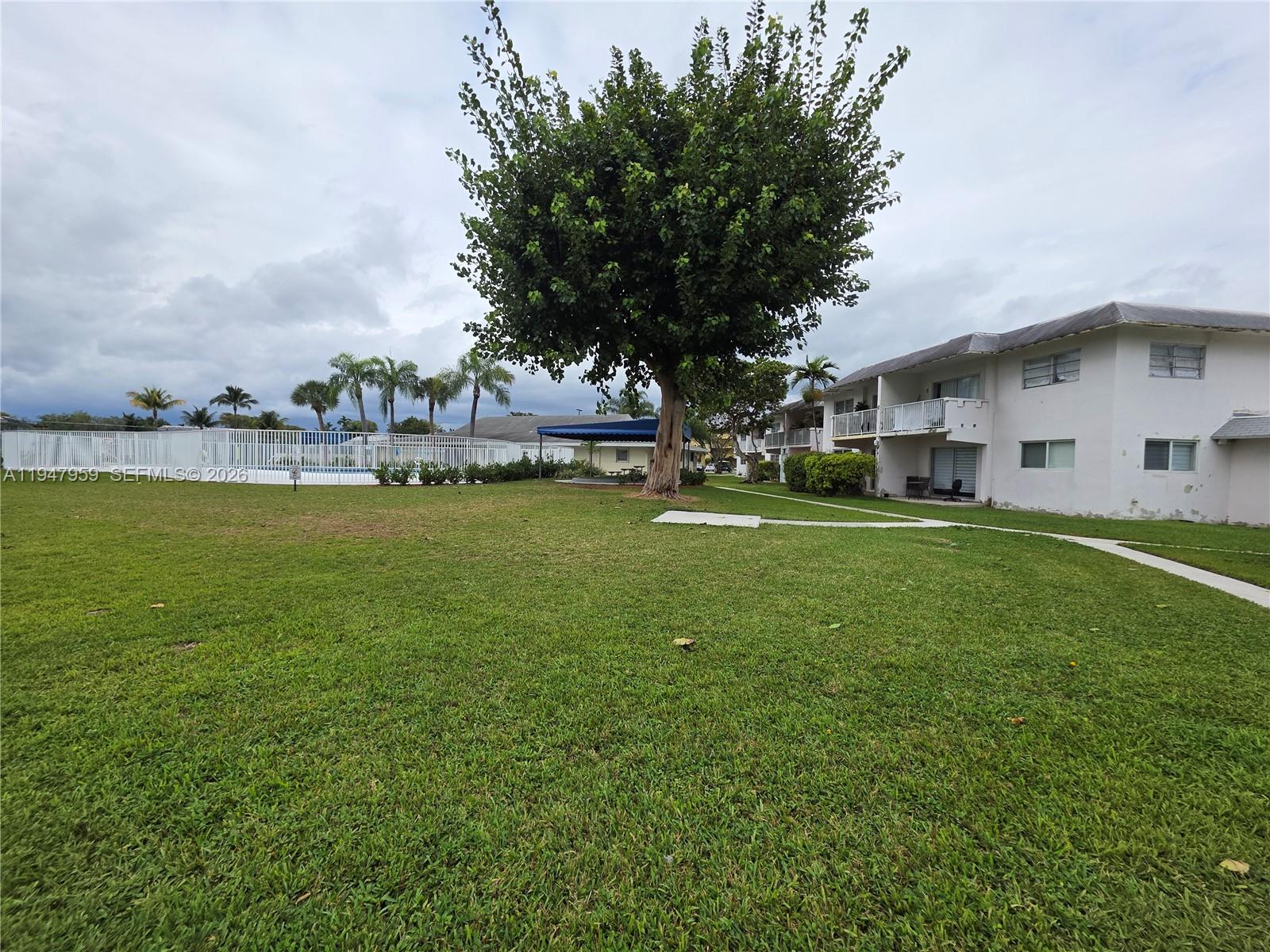 7424 Southwest 82nd Street, Unit D215 Miami, FL 33143 - Photo 32 of 33 a view of a house with a big yard and sitting area