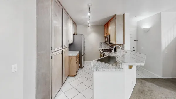 a kitchen with stainless steel appliances kitchen island a sink stove and refrigerator
