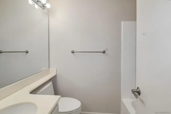 a white toilet sitting next to a shower