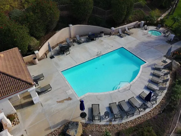 an aerial view of a house with a yard and furniture