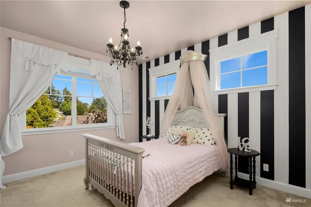 a spacious bedroom with a bed and a chandelier