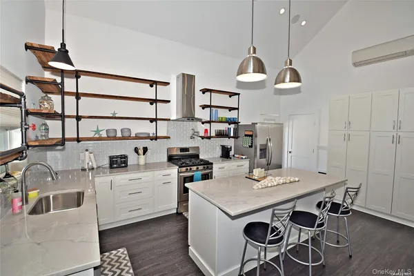 a kitchen with stainless steel appliances a stove a sink a dining table and chairs