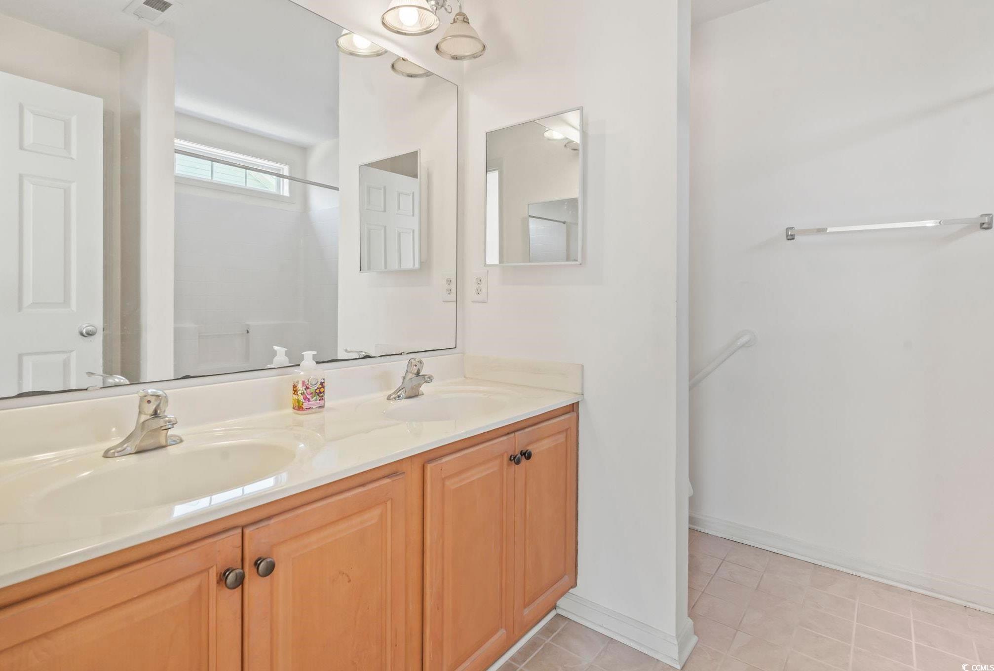 717 West Perry Road Myrtle Beach, SC 29579 - Photo 15 of 29 Full bathroom with double vanity, light tile patterned floors, and a tub/shower combo