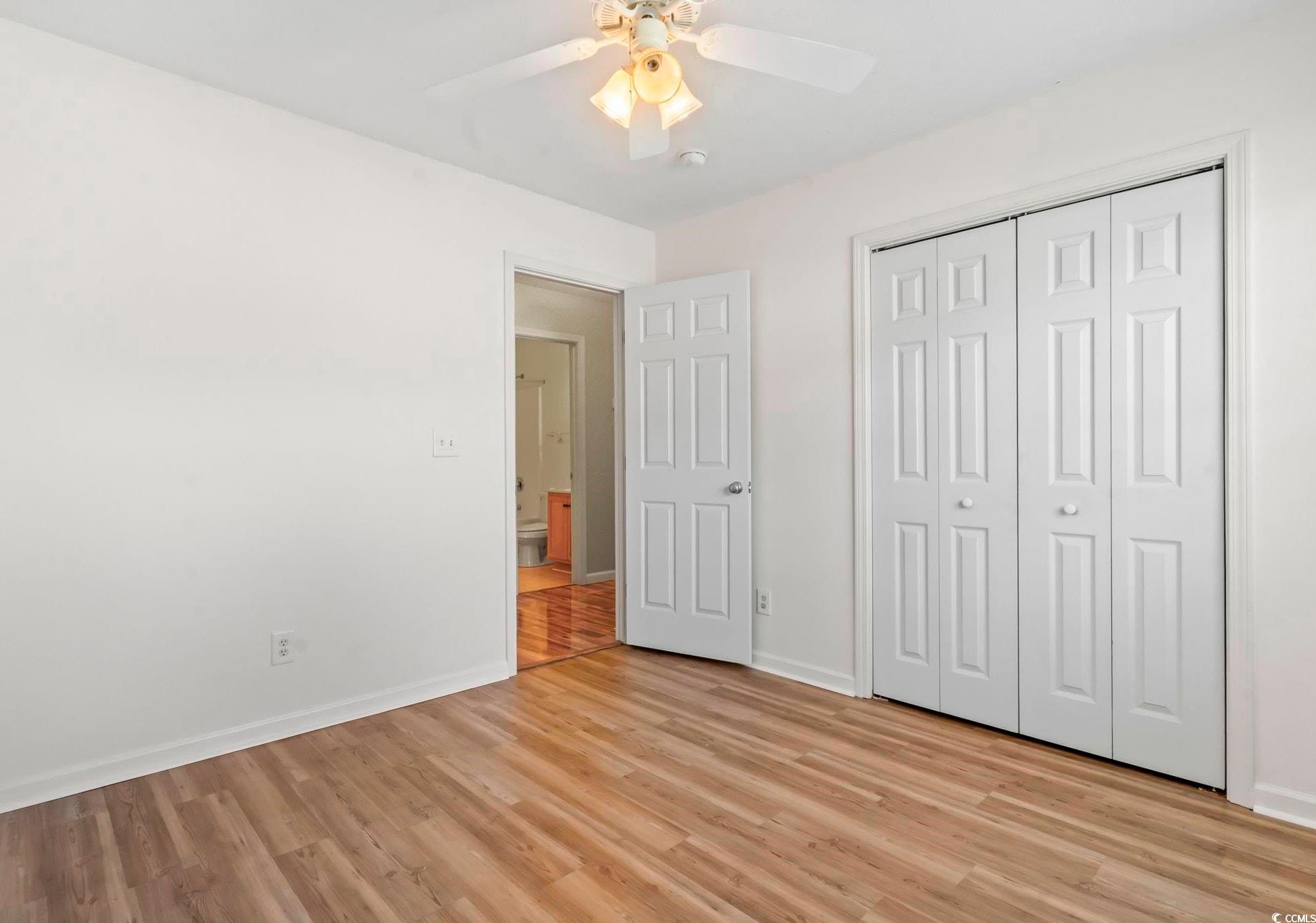 717 West Perry Road Myrtle Beach, SC 29579 - Photo 19 of 29 Unfurnished bedroom with light wood finished floors, a closet, and a ceiling fan