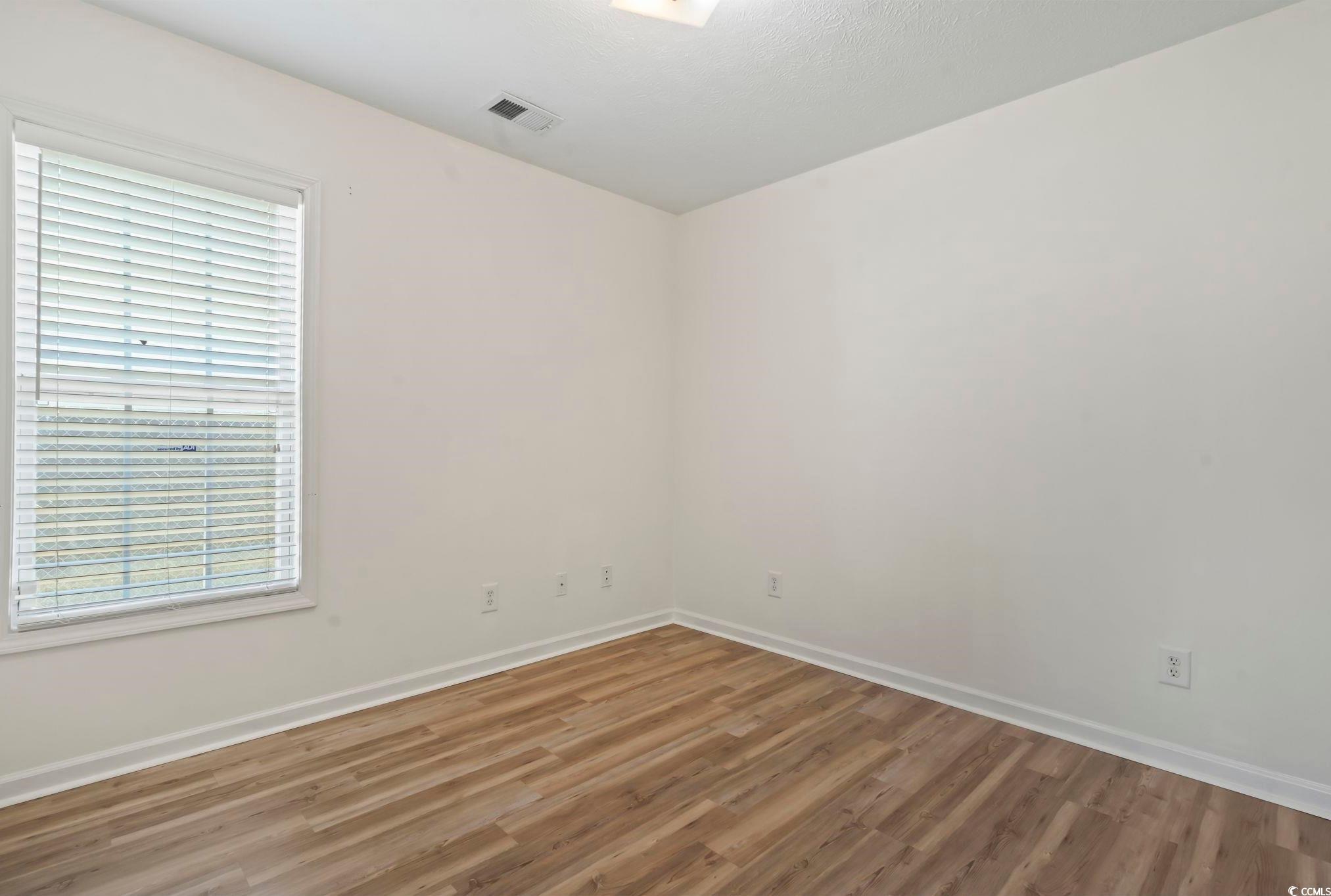 717 West Perry Road Myrtle Beach, SC 29579 - Photo 20 of 29 Empty bedroom with wood finished floors and baseboards