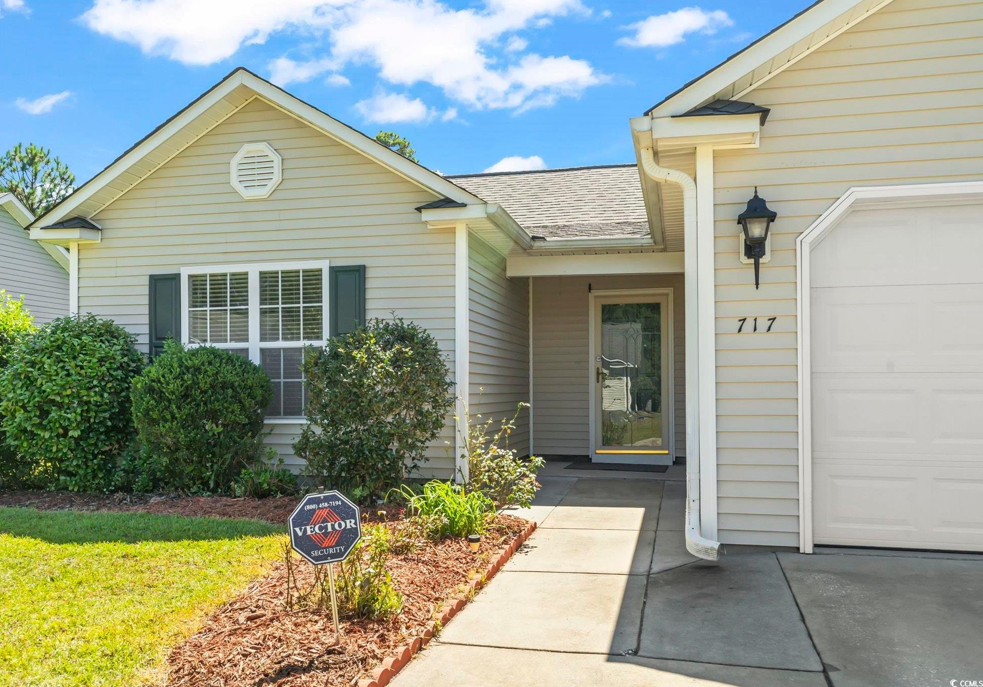 717 West Perry Road Myrtle Beach, SC 29579 - Photo 2 of 29 Entrance to property featuring a shingled roof, a garage, and a lawn